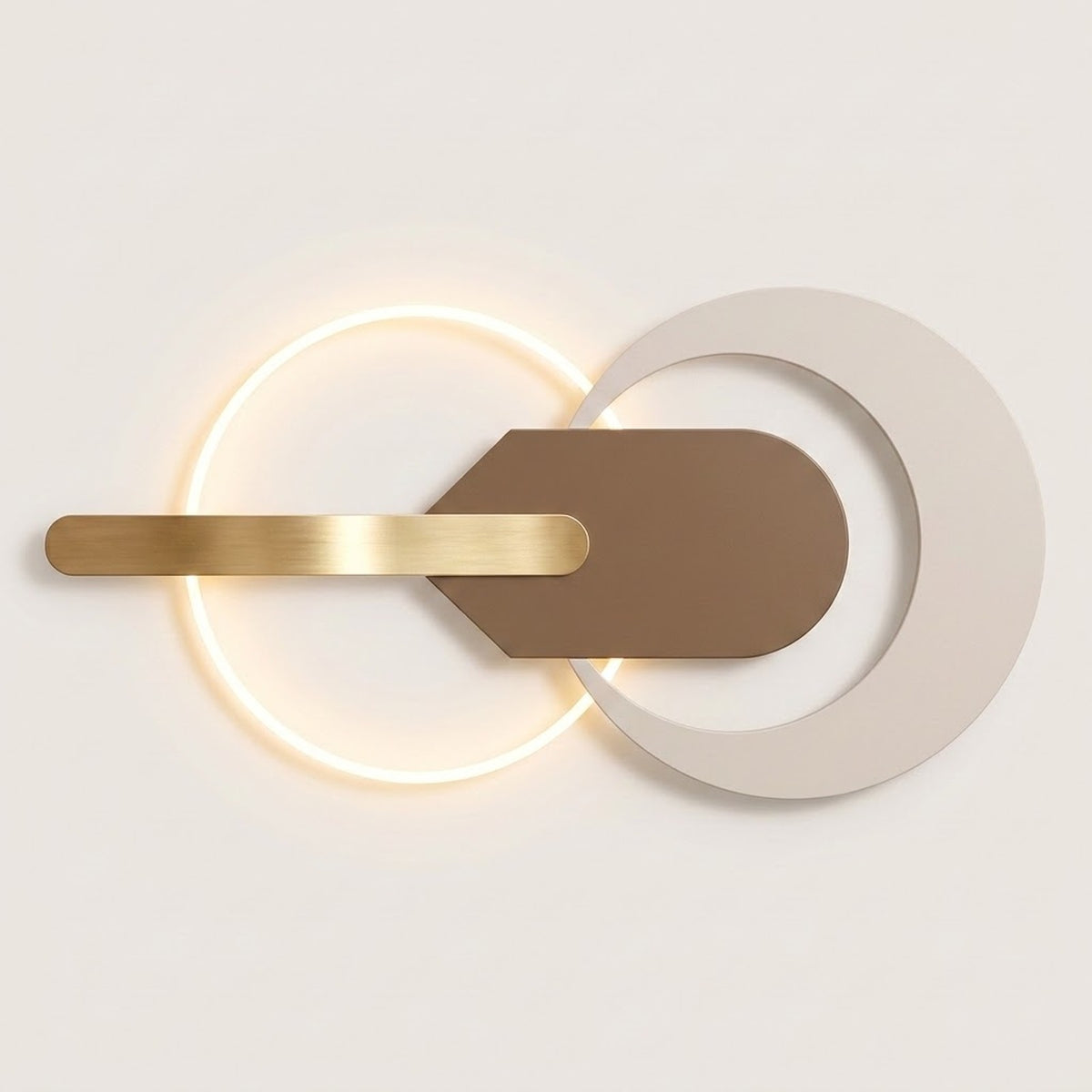 Modern wall sconce with a glowing circular light, a horizontal brushed gold bar, and overlapping matte white and taupe geometric shapes on a light neutral background.
