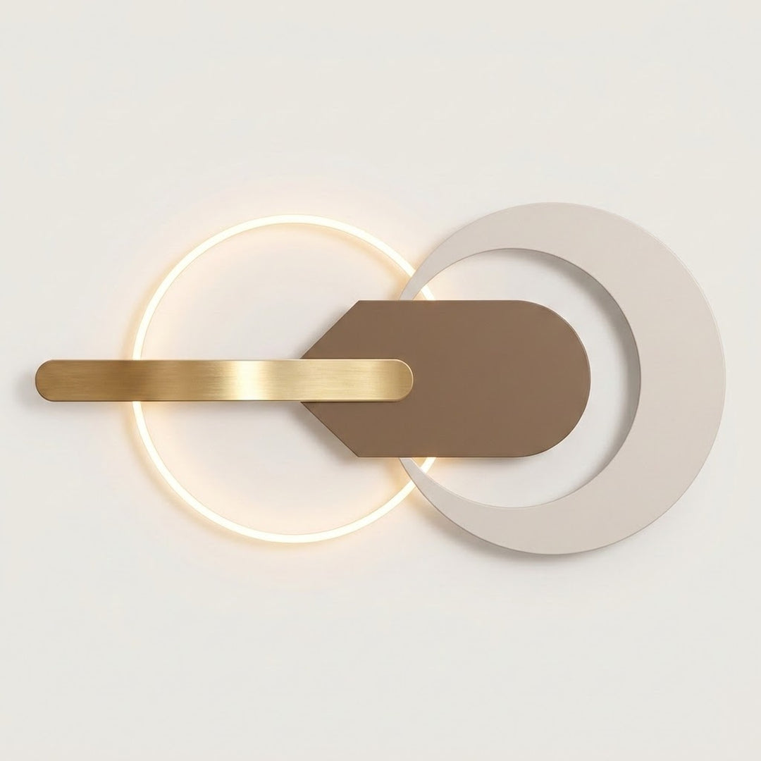 Modern wall-mounted light fixture with a glowing circular ring, a horizontal brushed gold bar, and overlapping matte white and taupe geometric shapes on a clean off-white background.