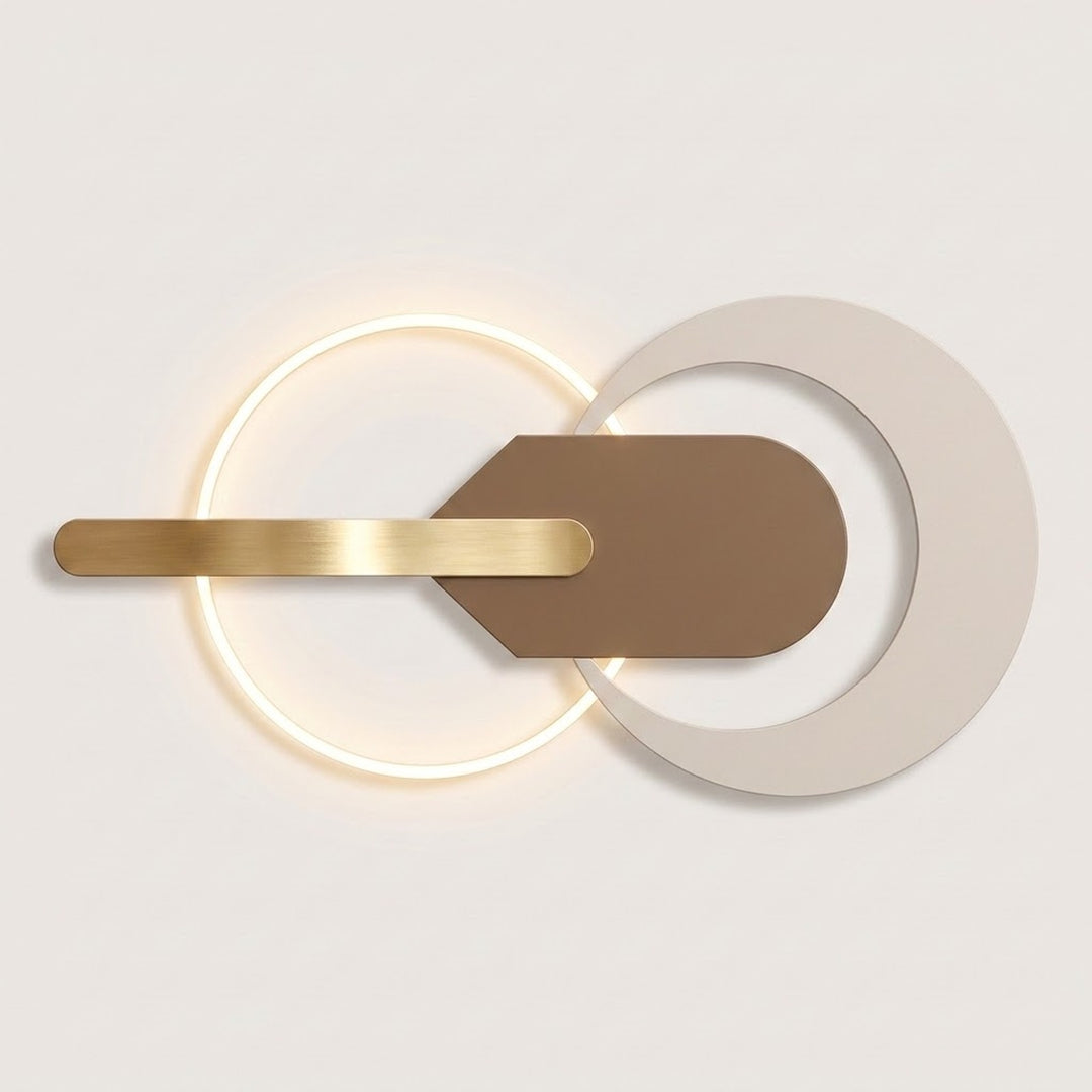 Modern wall sconce with a glowing circular ring, a horizontal brushed gold bar, and overlapping matte white and brown geometric shapes on a light neutral background.