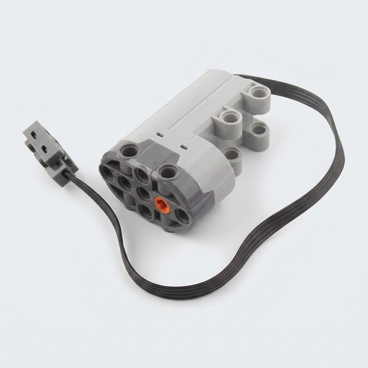 A gray building block servo motor component with mounting holes, an orange axle socket, and a looped black cable rests against white.