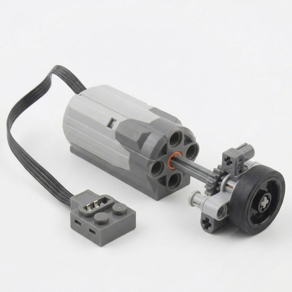 A grey building block motor component with black cable connects to a demonstration wheel and gear assembly against a white background.