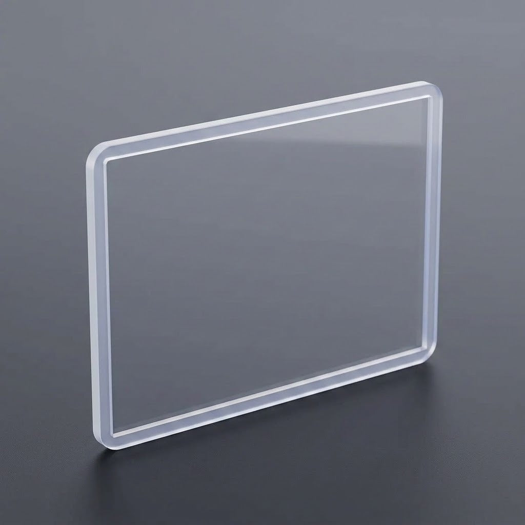 A transparent hard card sleeve with rounded corners stands upright on a dark gray surface.