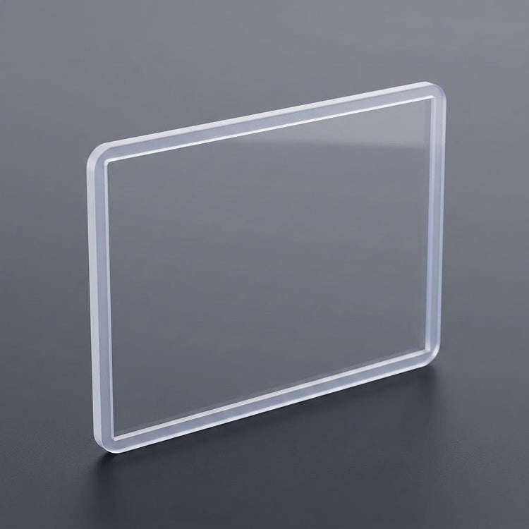 A transparent hard card sleeve with rounded corners stands upright on a dark gray surface.