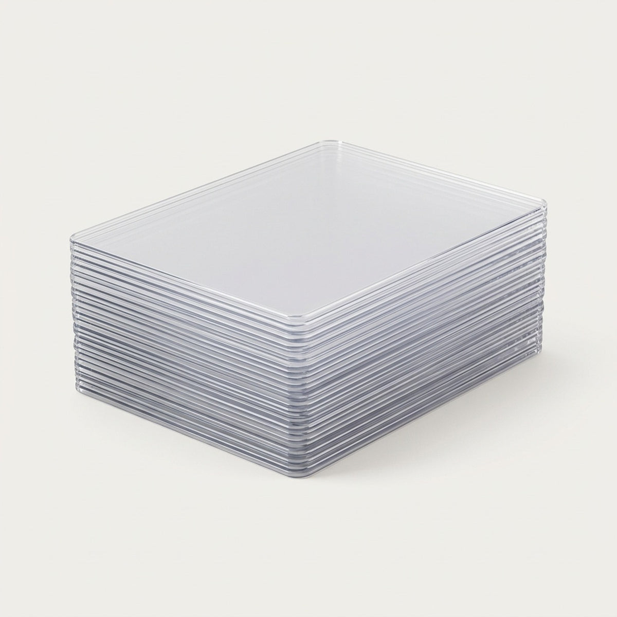 Clear plastic card sleeves are stacked neatly on a plain off-white background, showing their rigid edges and rounded corners.