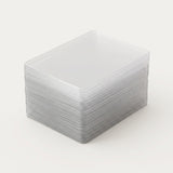 Clear hard card sleeves are stacked neatly with rounded corners and layered edges visible against a light background.