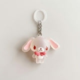 A cute translucent white bunny keychain charm with pink inner ears, red eyes, and a pink bow tie, attached to a silver chain and white key ring on a light gray background.