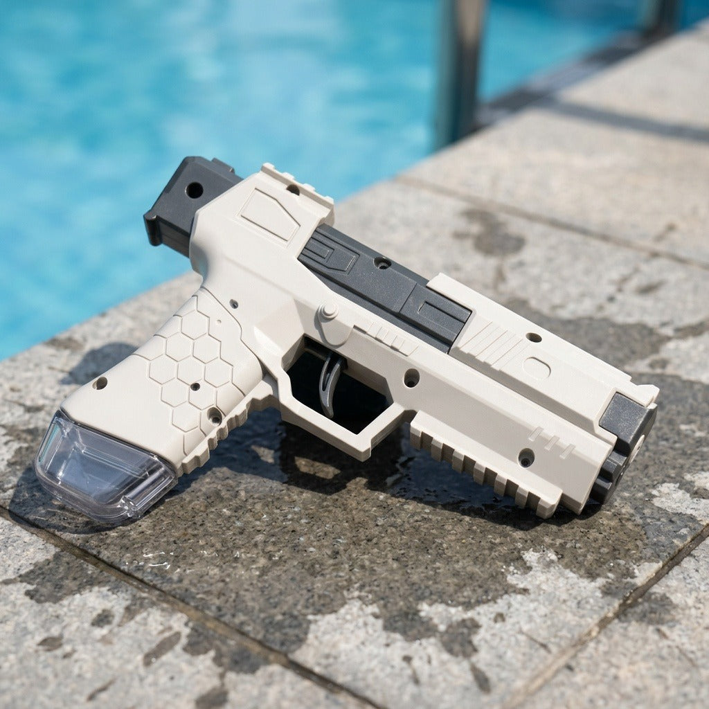 White and black water squirt gun with a clear reservoir lies on wet stone tiles beside a blue swimming pool.