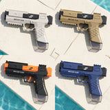 White, tan, black and orange, and blue water guns lie on pale stone tiles beside turquoise pool water.
