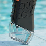 Water gun close-up shows a black hexagonal-textured grip and transparent reservoir partially filled with water against a blurred blue background.