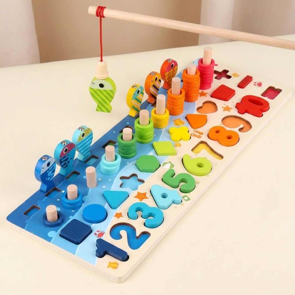 A wooden fishing rod suspends a green fish above a rainbow activity board with numbers, shapes, and rings on a cream tabletop.