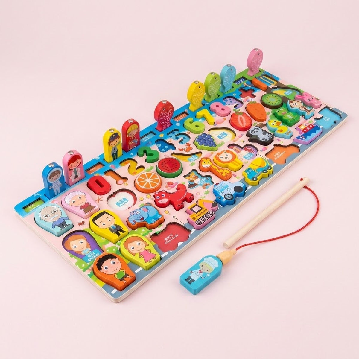 Wooden activity board with colorful people, animals, fruit, vehicles, numbers, upright fish, and a fishing rod on a pale pink background.