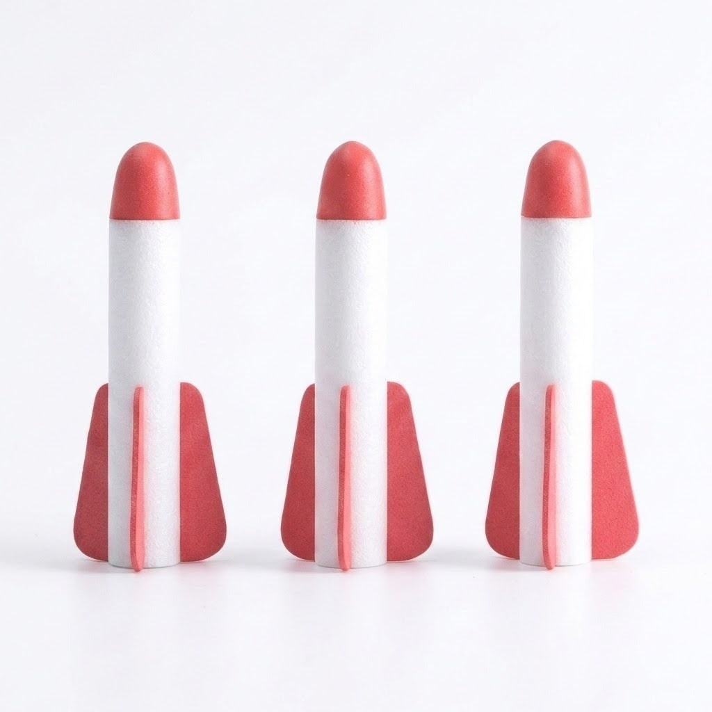 Three white foam rockets for a rocket launcher toy stand against a white background, each with a rounded red tip and red fins.