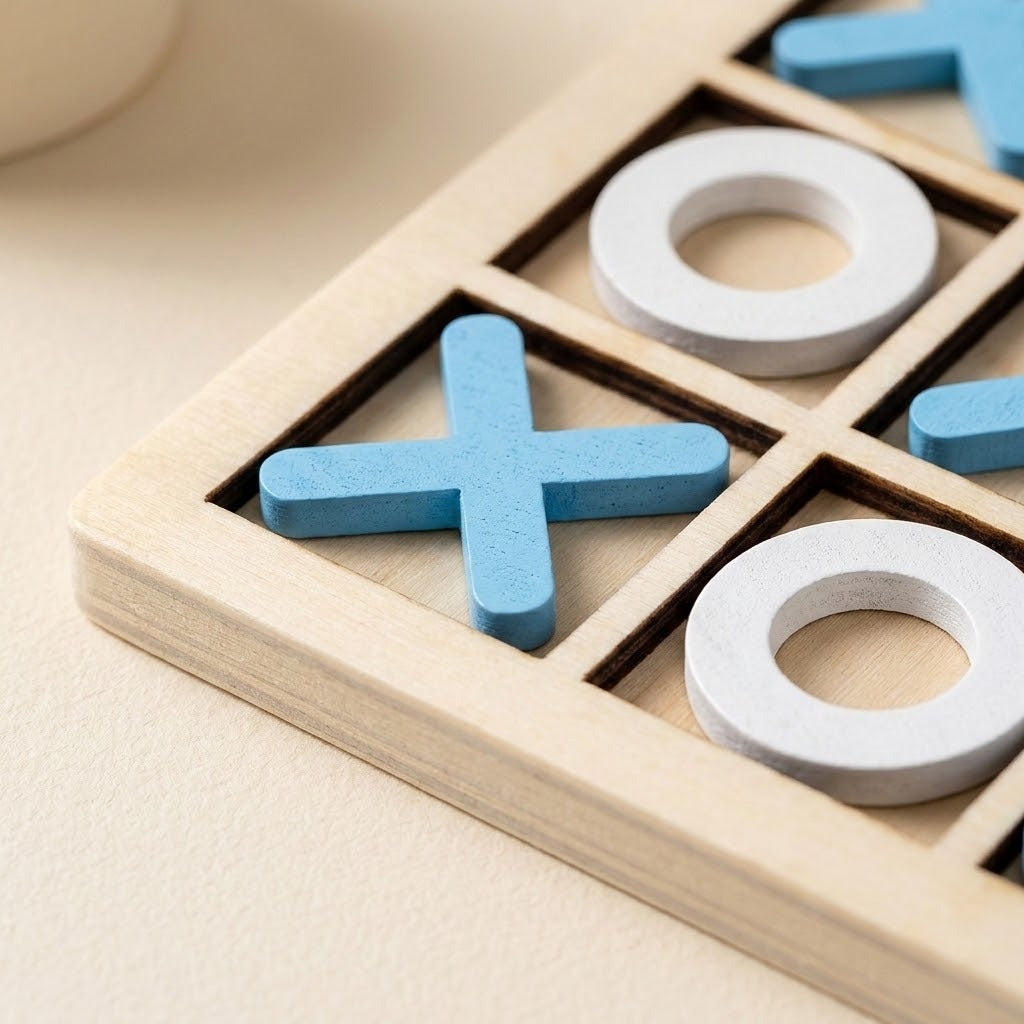 A close-up of a wooden tic-tac-toe game board with light blue cross pieces and white ring pieces on a warm beige surface.