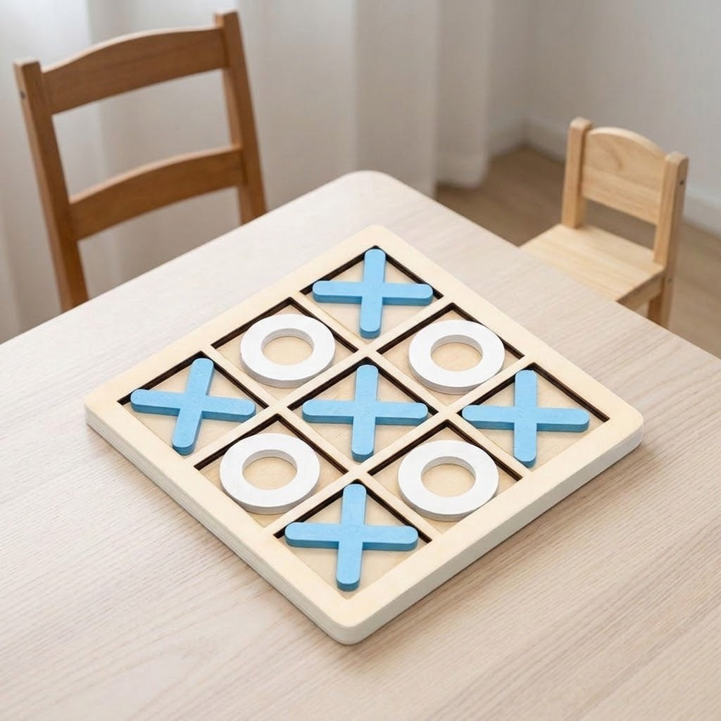 A wooden tic-tac-toe game board on a light wood table, with blue X shapes and white O shapes, and two small wooden chairs in the background.