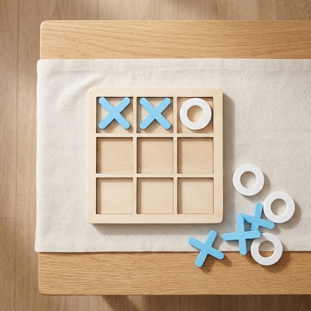 Wooden tic tac toe board game with blue X and white O pieces on a cream fabric runner over a wooden table.