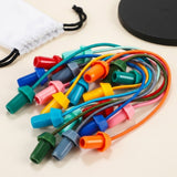 Rope puzzle close-up showing colorful elastic ropes and matching end pieces on a cream surface beside the bag and board edge.