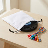 Black rope puzzle board sits partly inside a white drawstring bag, with bundled colorful ropes beside it on a light wooden table.