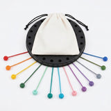 Rope puzzle with a white drawstring bag covering the black board and colorful ropes fanned outward against a white background.