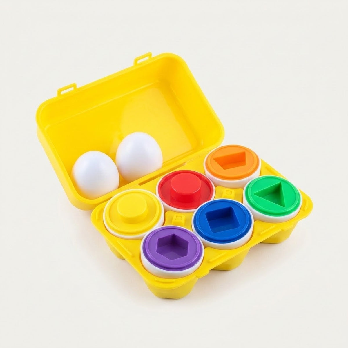 A children's shape-sorting toy set in a bright yellow plastic egg carton case, shown open on a clean white background. The set includes white egg-shaped pieces and six colored circular pieces in yellow, orange, red, green, blue, and purple, each with a matching geometric hole.