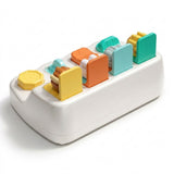 White pop-up toy viewed from behind, showing four upright colorful lids and differently shaped controls against a white background.
