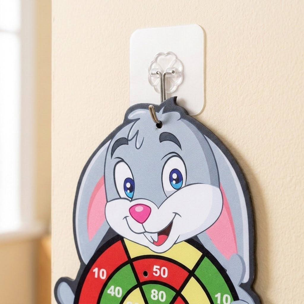 Close-up of a gray rabbit sticky ball target hanging from a square adhesive hook on a beige wall.