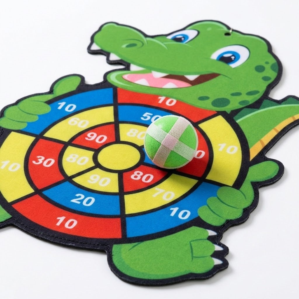 Green crocodile sticky ball target lying on white, with colorful numbered scoring sections and a green ball resting on its surface.