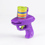Purple plastic disc shooter with a green lid and trigger holds colorful discs in a clear chamber against a white background.