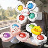 Rabbit, pig and duck suction spinner toys with colorful inserts and clear suction cups are displayed beside a train window.