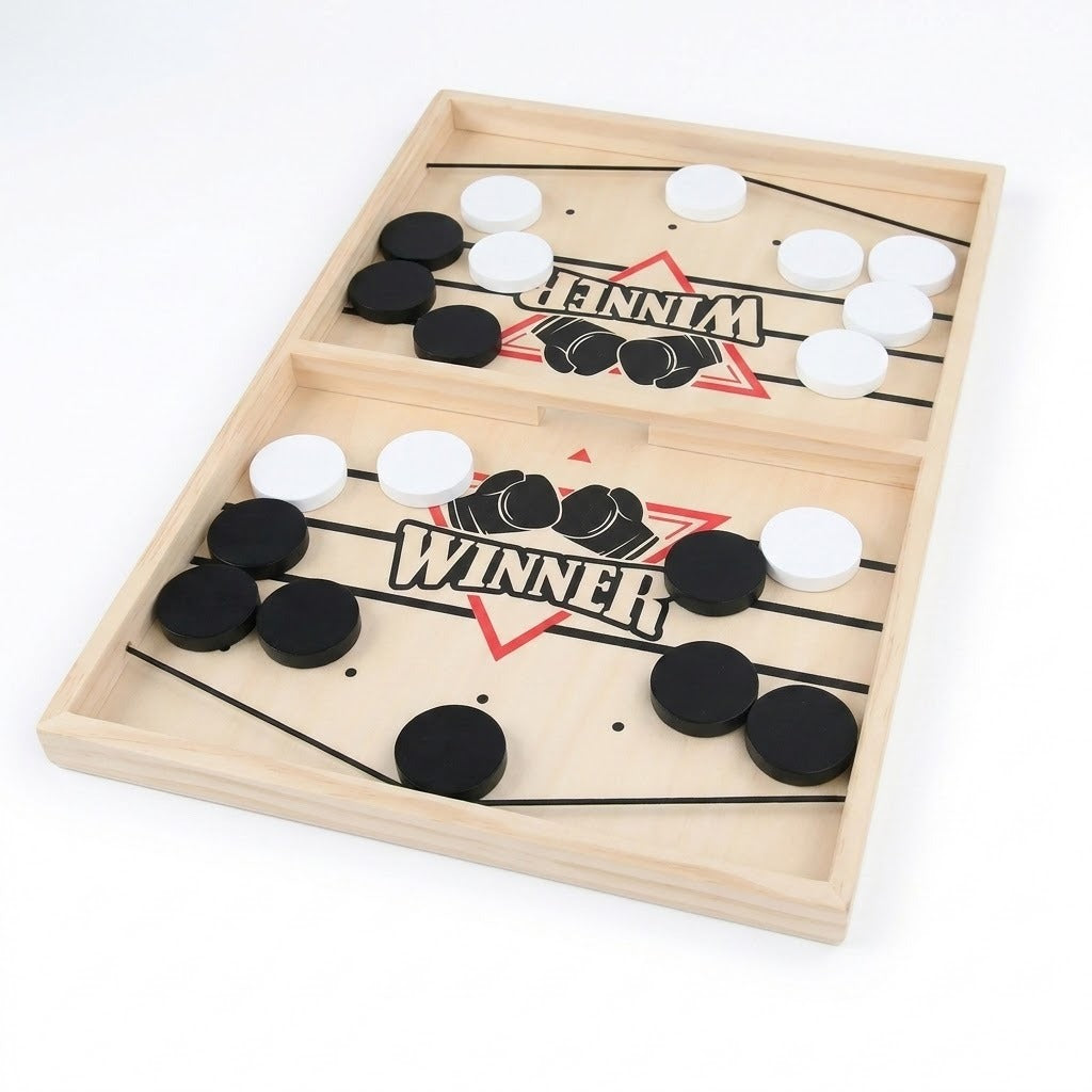 Wooden sling puck game with black and white pucks and black elastic cords, displayed diagonally against a white background.