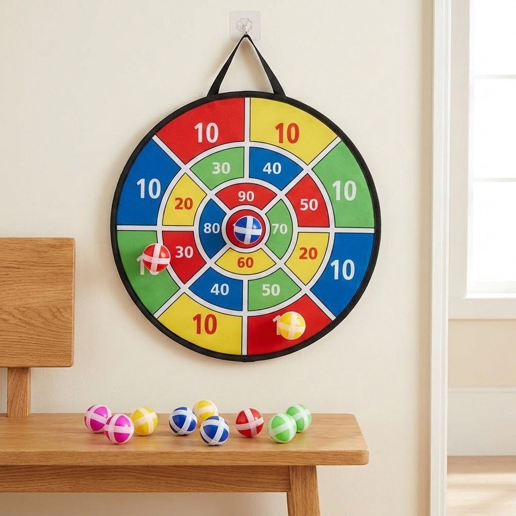 A colourful dart board with three sticky balls attached hangs on a beige wall above a wooden bench holding more balls.