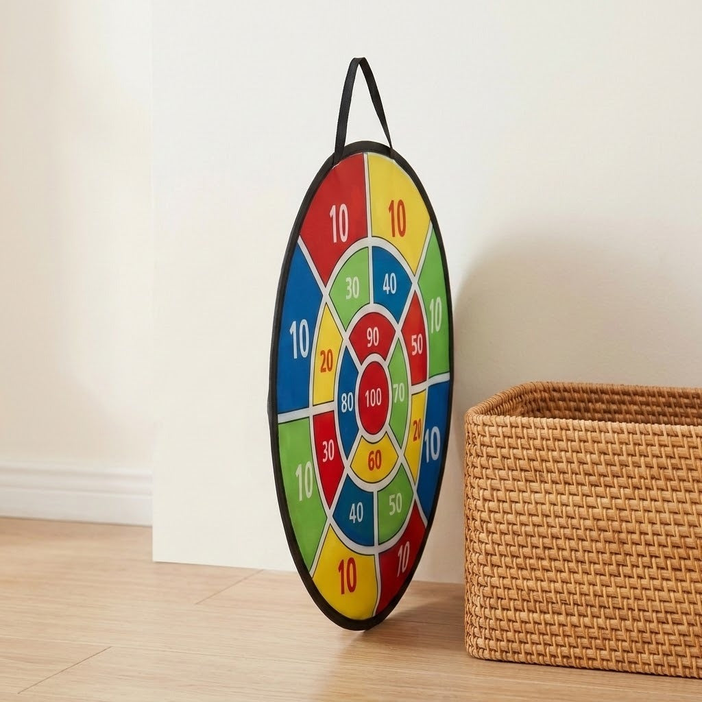 A colorful numbered dart board stands at an angle beside a woven basket on a light wooden floor against a white wall.