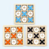 Three wooden 3x3 tic-tac-toe games shown on a light blue background, each with a natural wood frame and alternating blue, white, and orange or black shapes.