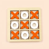 A wooden 3x3 tic-tac-toe game board with orange X shapes and white O shapes on a light beige background, set against a pale peach backdrop.