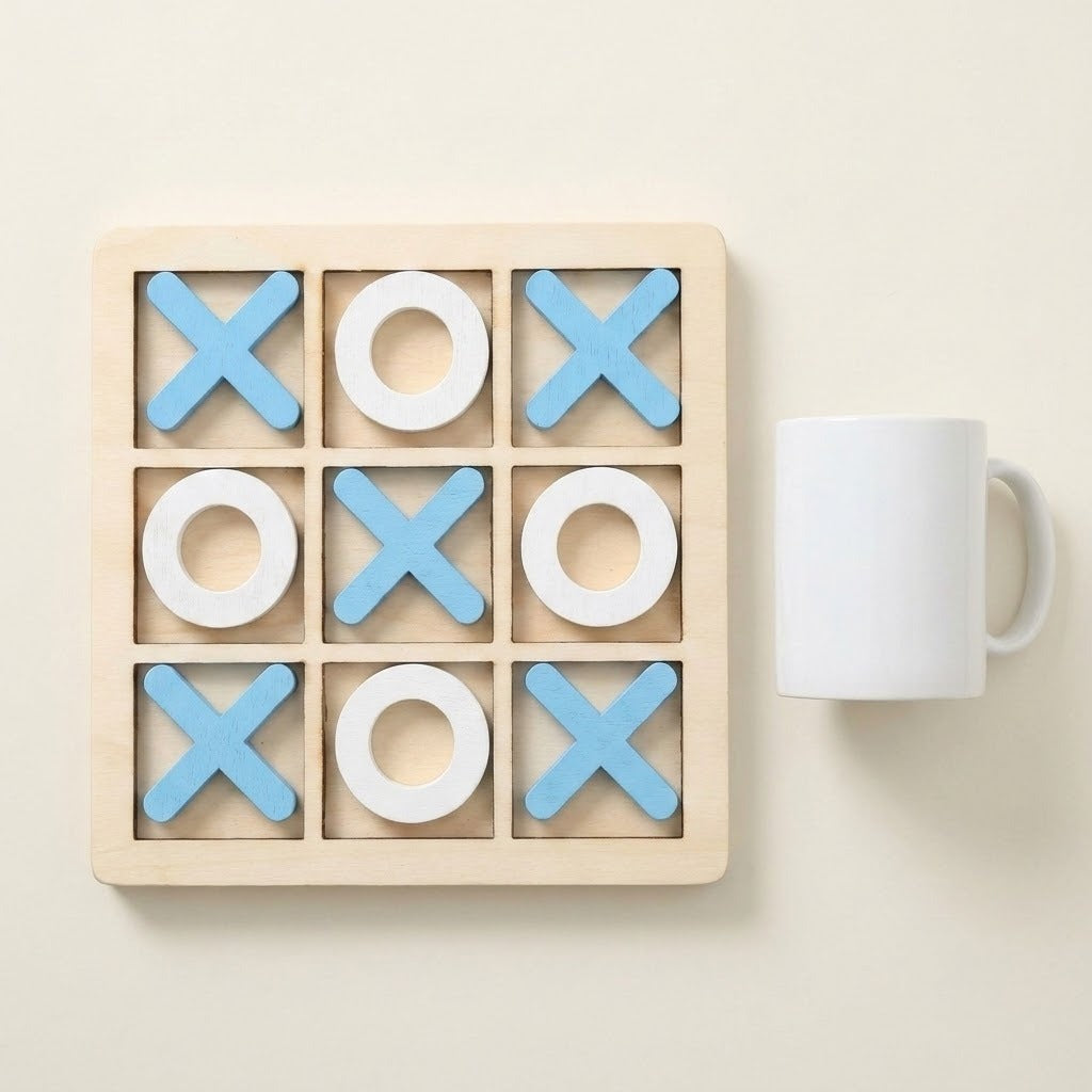 Wooden tic-tac-toe game with blue X pieces and white O pieces beside a white mug on a cream background.