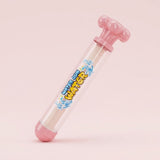 A pink plastic toy water gun with a clear barrel and colorful 'WATER ON WATER' label, set against a solid pale pink background.