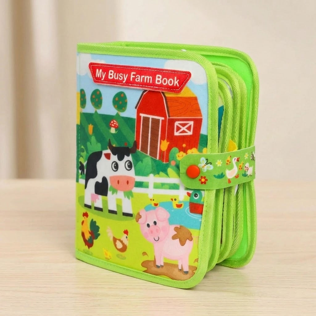 A children's zippered activity book titled 'My Busy Farm Book' with colorful cartoon farm illustrations including a cow, pig, chicken, barn, and duck. The book is standing upright on a light wood surface against a soft beige background.