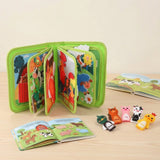 Green fabric busy book stands with pages fanned open on a wooden surface beside animal finger puppets and two open illustrated books.