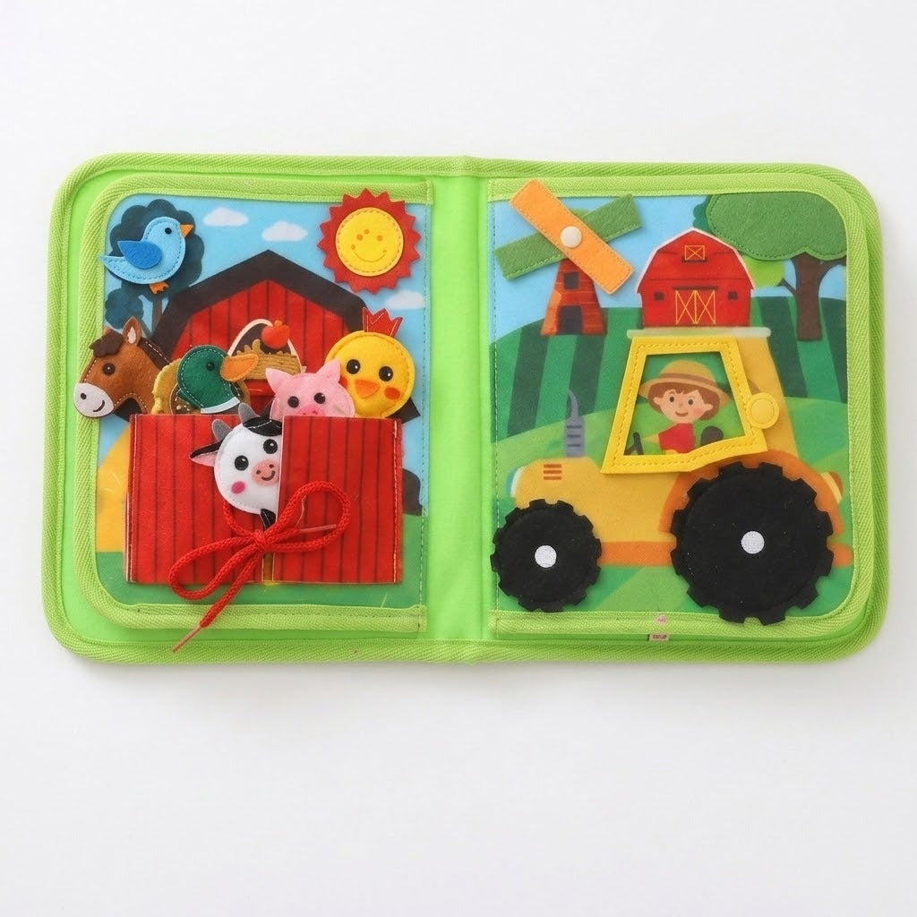 Green fabric busy book open flat on white, with animal puppets tucked into a red barn pocket beside a yellow tractor.