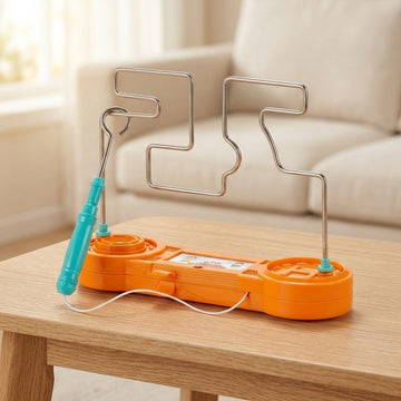 Orange buzz wire game with a turquoise loop wand and winding silver-colored track on a wooden table beside a cream sofa.