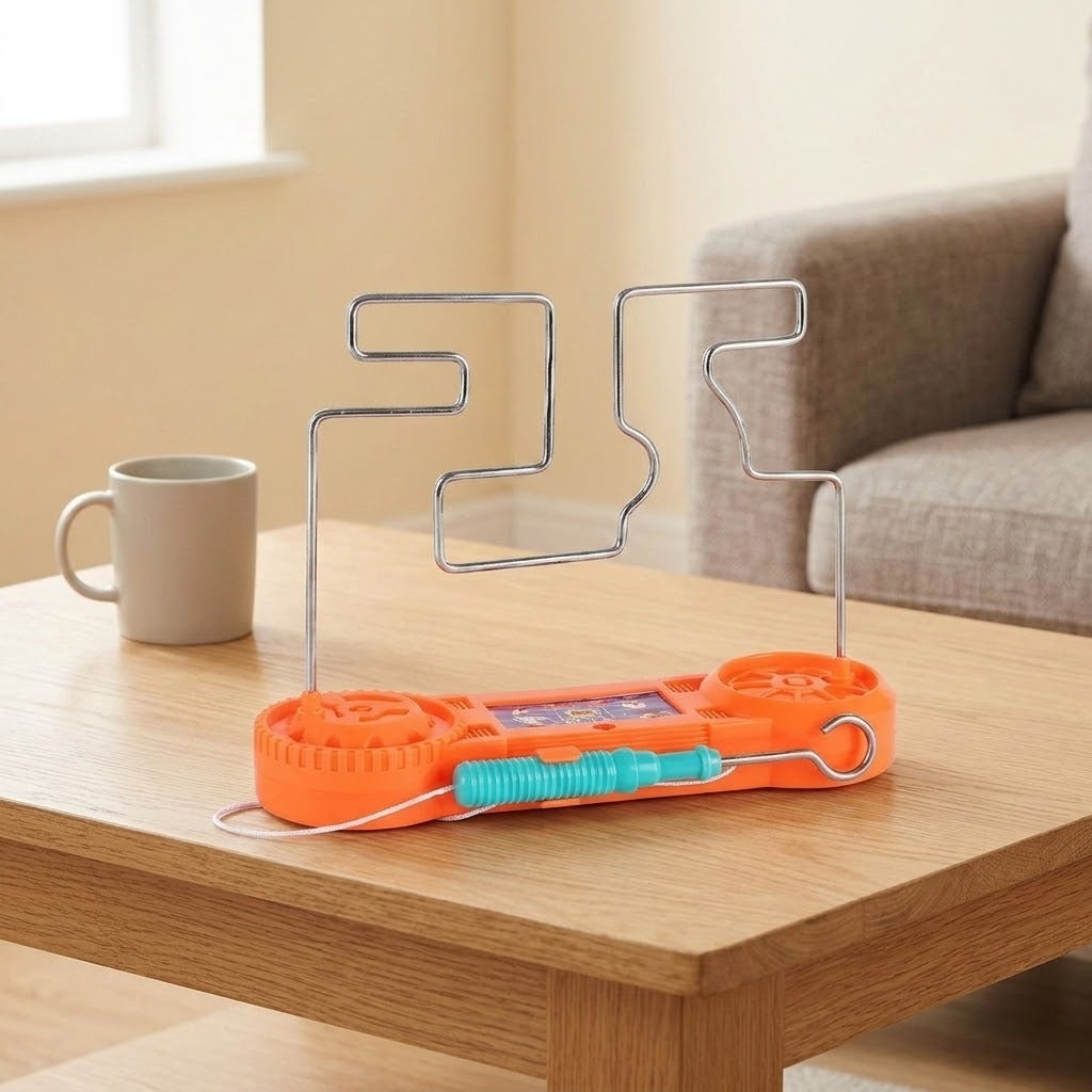 Orange buzz wire game with its turquoise wand resting across the front on a wooden table beside a mug and gray sofa.