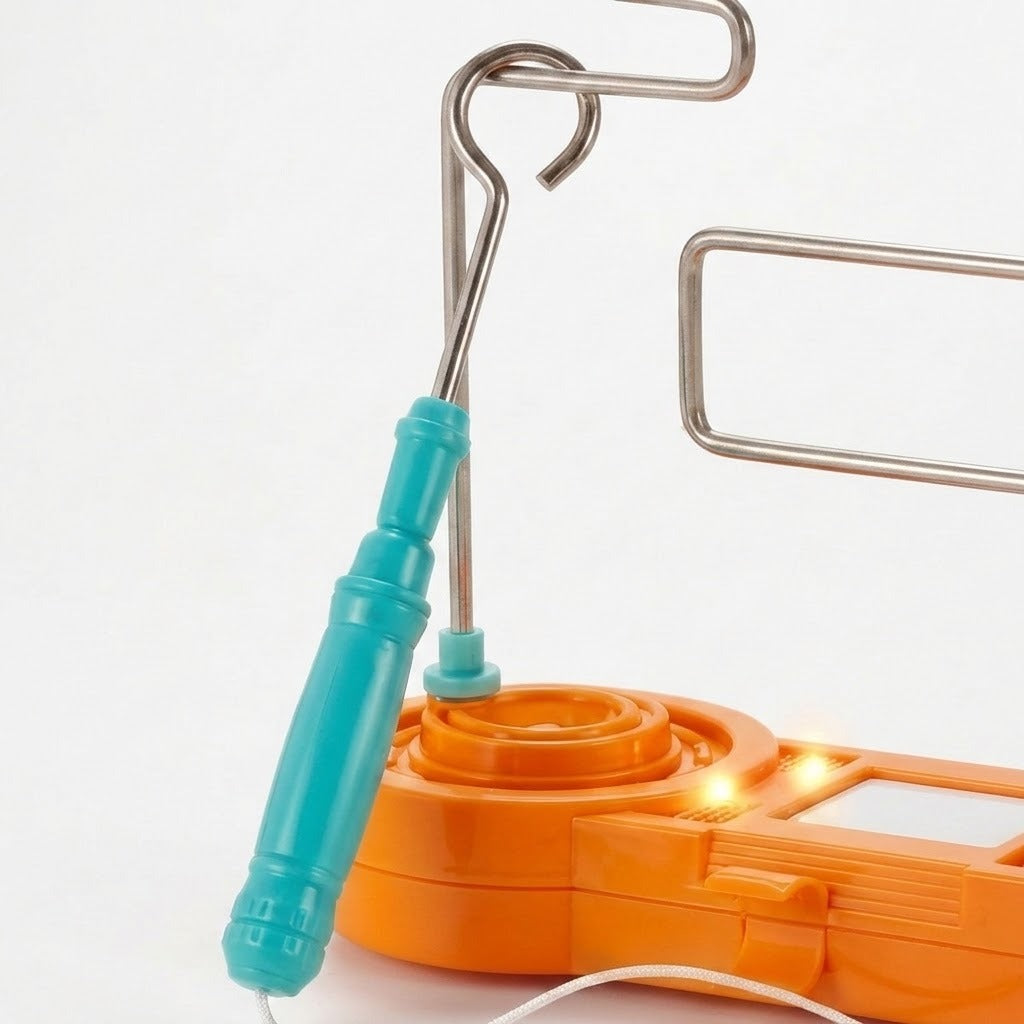 Buzz wire game close-up shows a turquoise wand loop around the silver wire course above an illuminated orange plastic base against white.