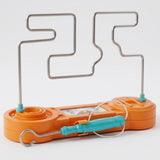 Orange buzz wire game with a turquoise cord-connected wand resting across its front and an upright silver-colored maze against a white background.