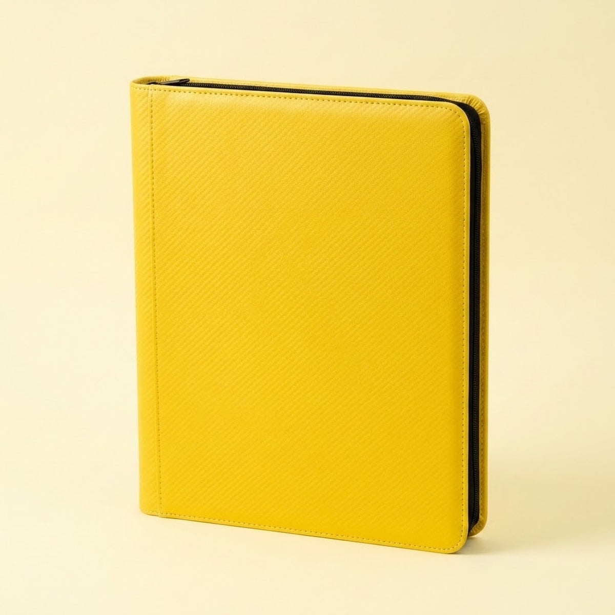Upright yellow zippered trading card binder with a smooth cover and black zipper trim on a plain cream background.