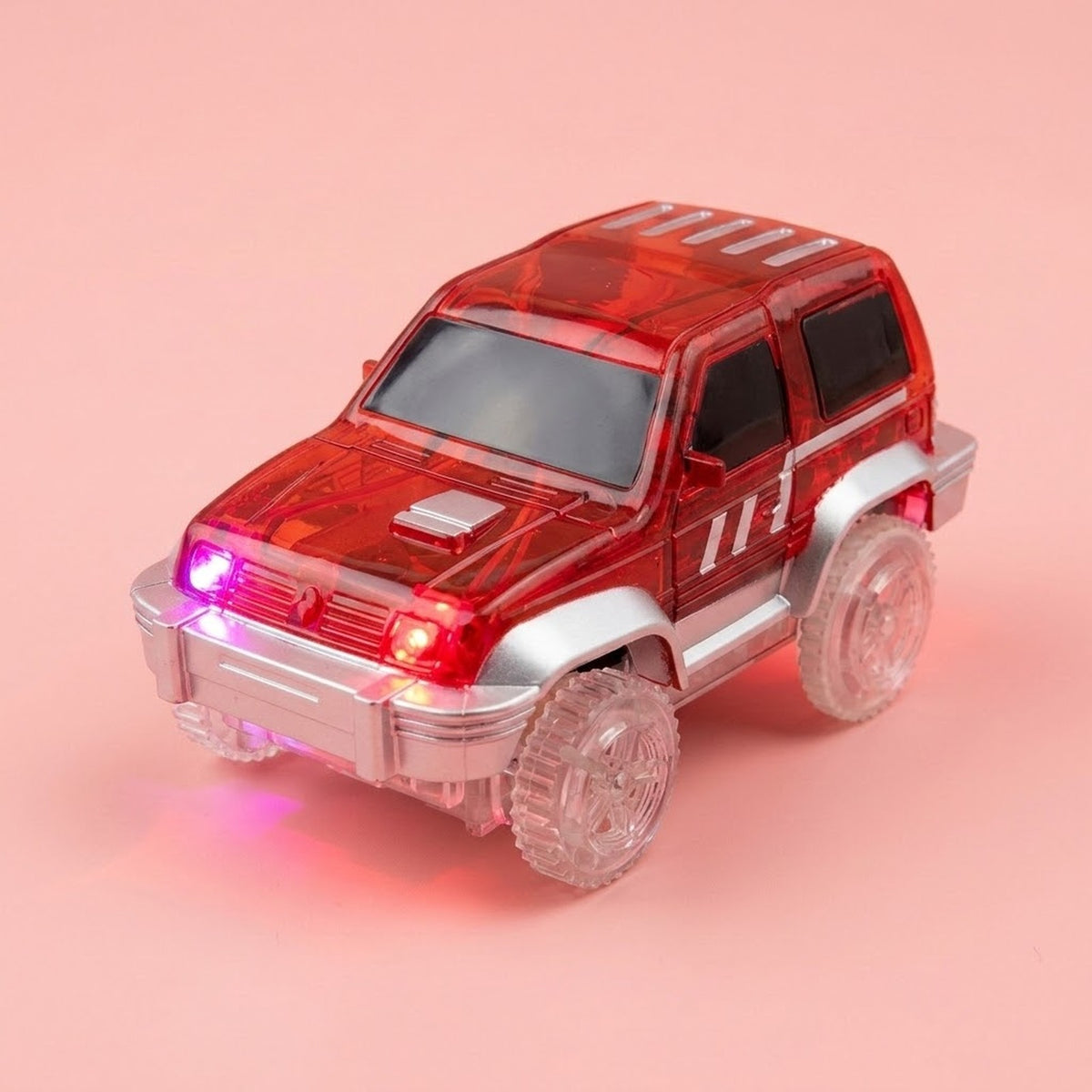 A red translucent toy SUV with clear plastic wheels and glowing pink and red lights, set against a solid pink background.