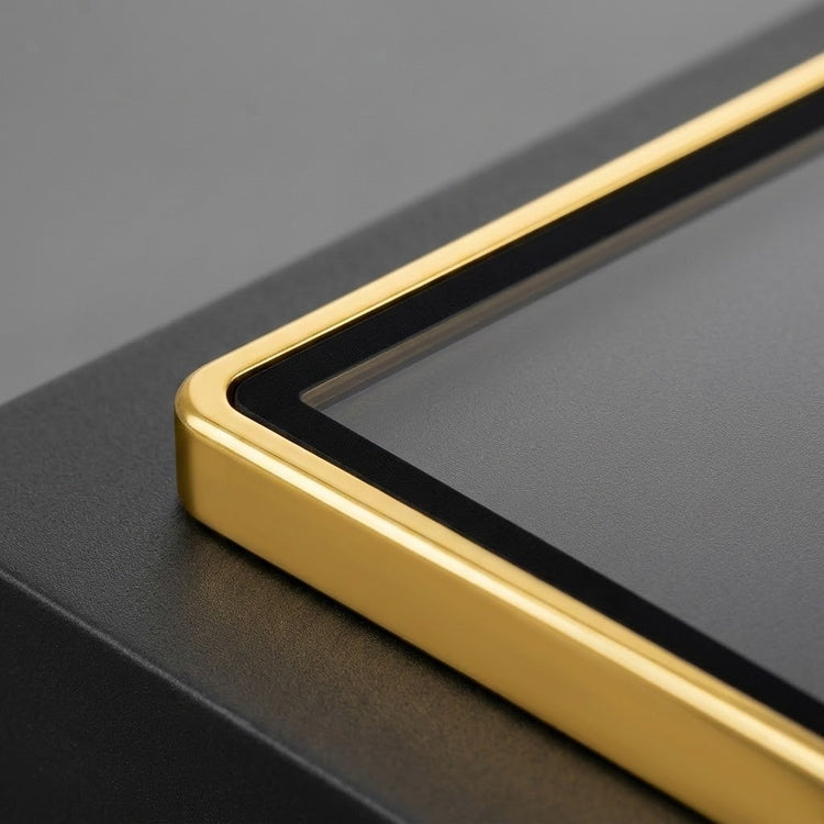 Close-up shows the gold aluminum alloy corner and black inner border of a graded card protector on a dark surface.