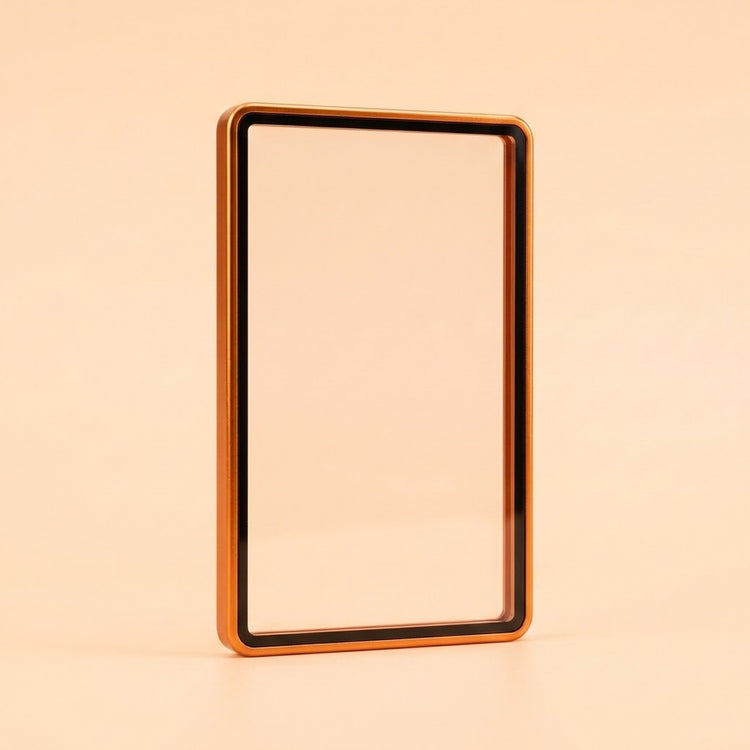 Metallic orange aluminum alloy graded card protector with a clear center and black inner border stands against a peach background.