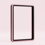 Pink aluminum alloy graded card protector with a black inner border and clear center stands upright against a pale pink background.