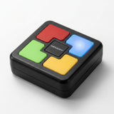 A black plastic electronic memory game with red, green, yellow, and glowing blue buttons sits on a white background.