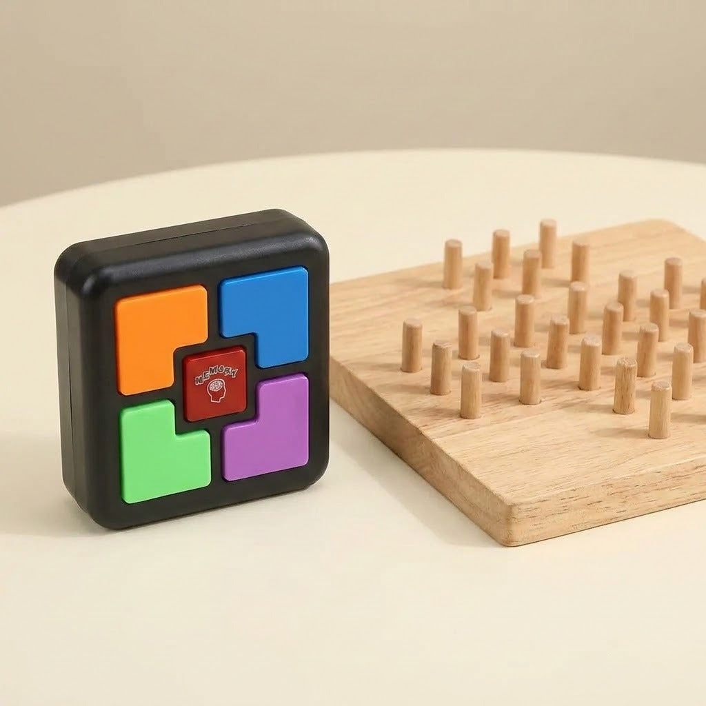 A black plastic electronic memory game with colorful buttons stands beside a wooden pegboard on a cream tabletop.