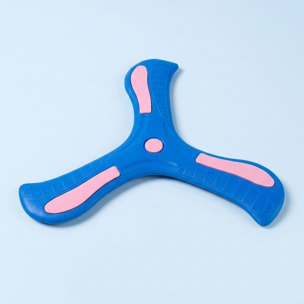 A blue three-blade EVA boomerang with pink blade accents and a pink center circle lies on a light blue background.